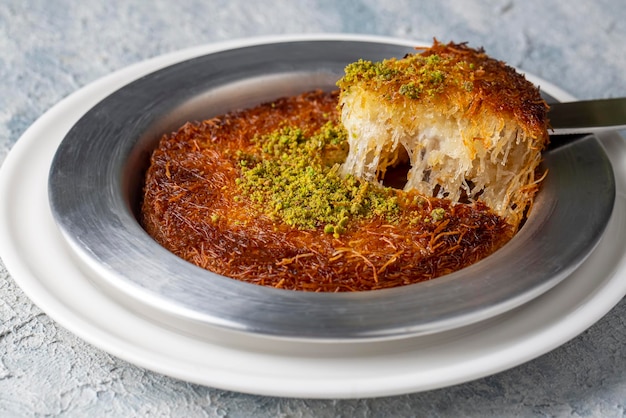 Delizioso kunefe turco tradizionale con sopra il pistacchio. Servire caldo e con sciroppo