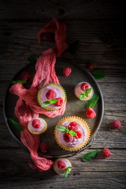 Delizioso muffin ai lamponi con frutti di bosco e crema rosa