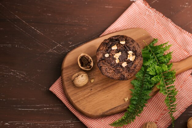 Delizioso muffin al cioccolato fatto in casa con noci sul tavolo. Pronto a mangiare.