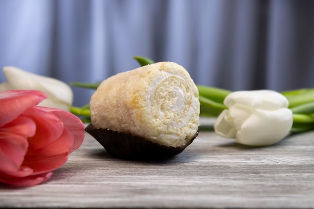 Delizioso pan di spagna con fiori bianchi e rosa sullo sfondo