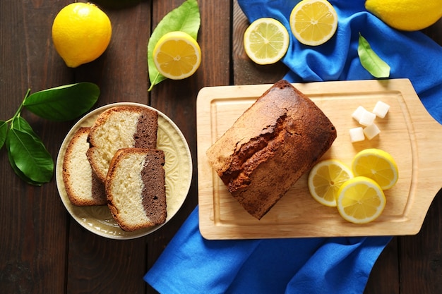 Delizioso pane dolce con limoni sul tavolo di legno, vista dall'alto