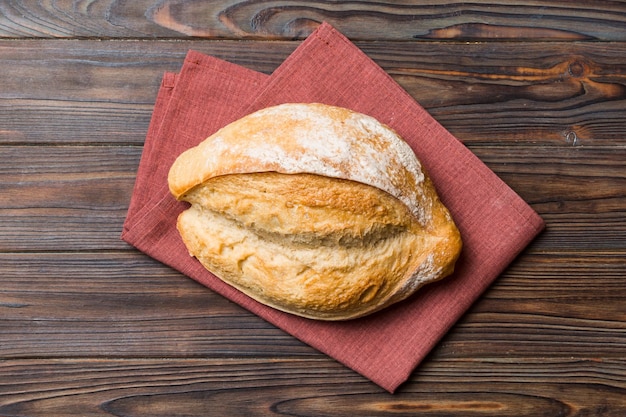 Delizioso pane francese appena sfornato con tovagliolo su tavolo rustico vista dall'alto Pane bianco sano