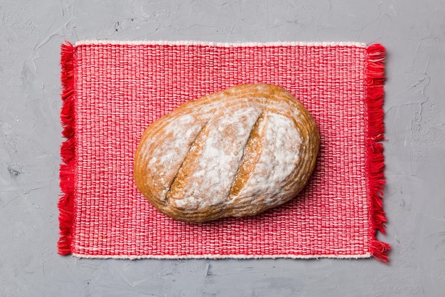 Delizioso pane francese appena sfornato con tovagliolo su tavolo rustico vista dall'alto Pane bianco sano