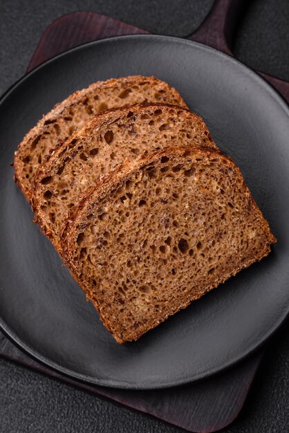 Delizioso pane integrale fresco e croccante con cereali e semi su uno sfondo di cemento scuro