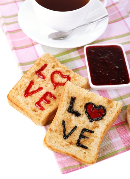 Delizioso pane tostato con marmellata e tazza di tè sul primo piano del tavolo