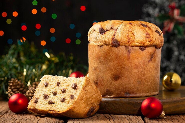Delizioso panettone con gocce di cioccolato su una tavola addobbata per Natale.