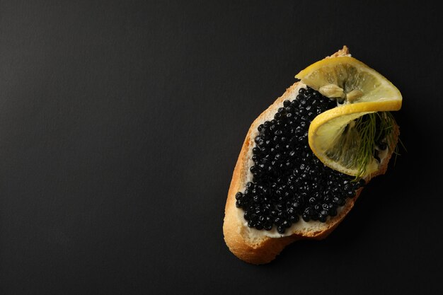 Delizioso panino con caviale su sfondo nero