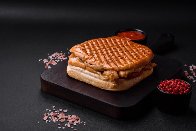 Delizioso panino croccante con petto di pollo pomodori ketchup e spezie