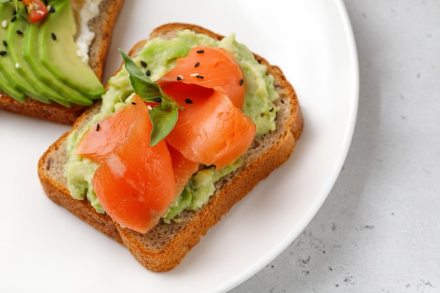 Delizioso panino o spuntino sano con salmone avocado Primo piano Toast all'avocado su pane integrale