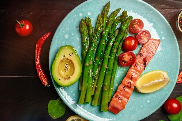 Delizioso piatto di asparagi e pomodori con vista dall'alto di avocado filetto di pollo alle erbe