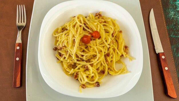 Delizioso piatto di spaghetti alla carbonara su tavola di legno