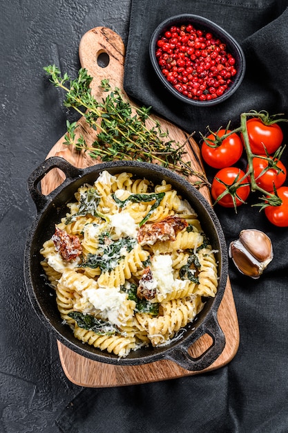 Delizioso piatto fusilli di pasta con salsa cremosa di spinaci e pomodori secchi