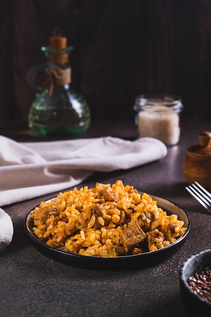 Delizioso pilaf asiatico con carne su un piatto sul tavolo vista verticale