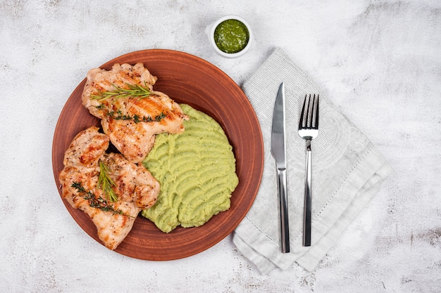 Delizioso pollo alla griglia con erbe e purea verde.