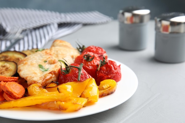 Delizioso pollo cotto e verdure sul tavolo grigio primo piano Pasti sani dalla friggitrice ad aria