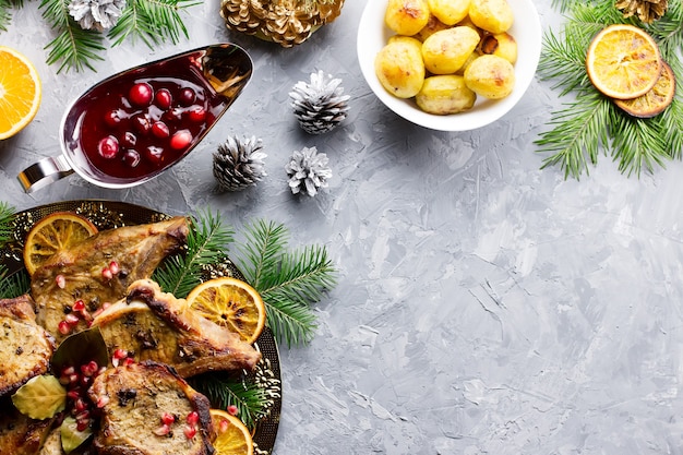 Delizioso pranzo di Natale con bistecca di carne arrosto, insalata di ghirlande di Natale, patate al forno, verdure grigliate, salsa di mirtilli rossi.