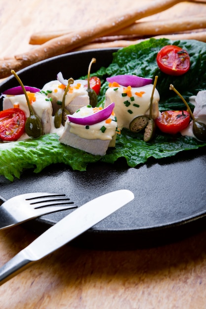 Delizioso ristorante piatto Vitello Tonato nel ristorante. Sano cibo esclusivo sul grande primo piano piatto nero