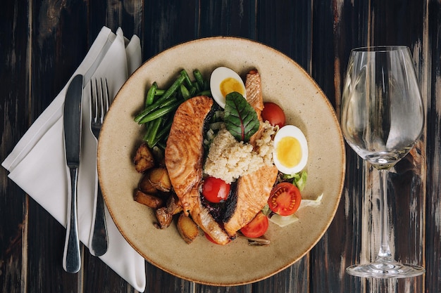 Delizioso salmone pescato nell'oceano Servito con fagiolini e un uovo di pomodoro couscous e patate