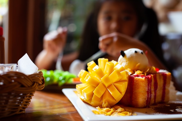 Delizioso toast al miele con fetta di mango e gelato per bambini dopo pasto