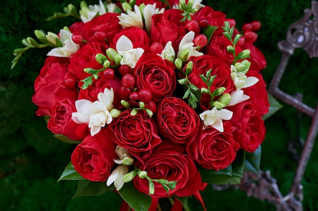 Denso bouquet di rose rosse con frutti di bosco e decorazioni Chiudere