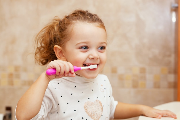 Dente di pulizia della bambina sveglia con la spazzola.