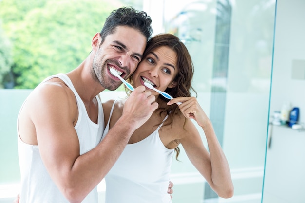 Denti di spazzolatura delle giovani coppie mentre stando nel bagno