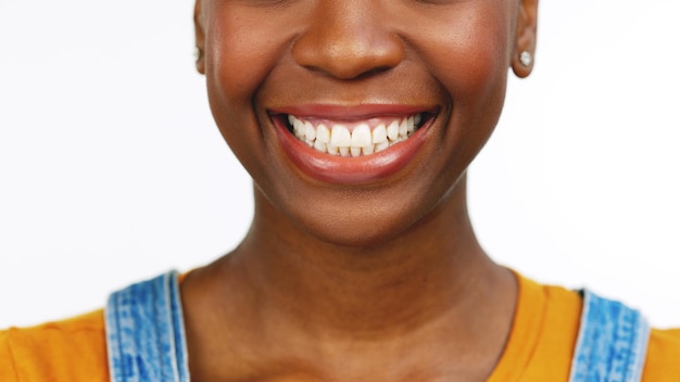 Denti e sorriso della donna di colore per lo sbiancamento delle cure dentistiche o l'assistenza sanitaria su uno sfondo bianco dello studio Felice femmina afroamericana isolata che sorride per la bocca del dente o la gomma e l'igiene orale