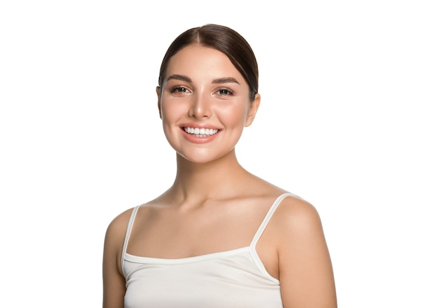 Denti sani sorriso donna pelle pulita trucco naturale ritratto femminile su sfondo grigio. Colpo dello studio.