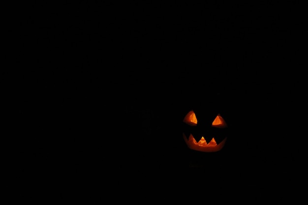denti scoperti di Halloween fantasma di zucca con candela accesa all'interno Fantasma di Halloween con posto vuoto nero per il testo