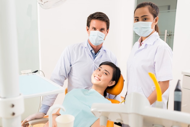 Dentista, assistente e paziente sorridente