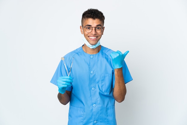 Dentista brasiliano che tiene strumento isolato che punta al lato per presentare un prodotto