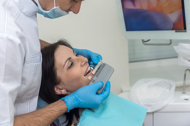 Dentista che confronta i denti del paziente con il campionatore della corona