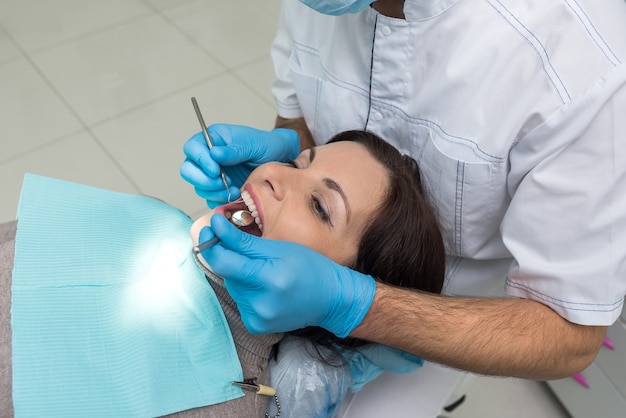 Dentista che confronta il colore dei denti del paziente con il campionatore