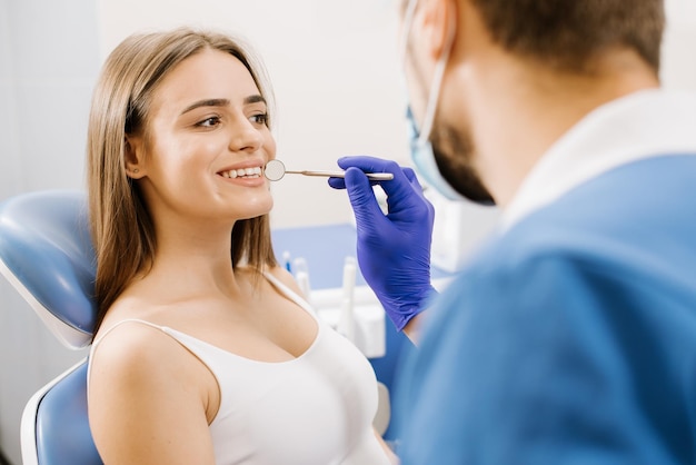 Dentista che controlla i denti dei pazienti con gli strumenti