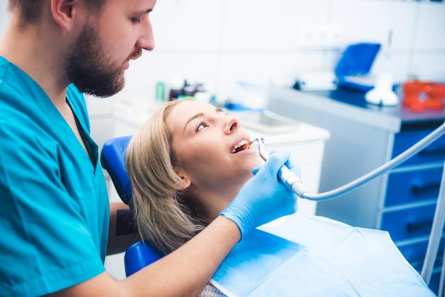 Dentista che cura ragazza bionda sorridente