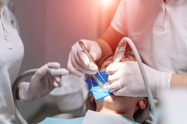 Dentista che cura una paziente di sesso femminile nei denti di stomatologia Concetto di trattamento