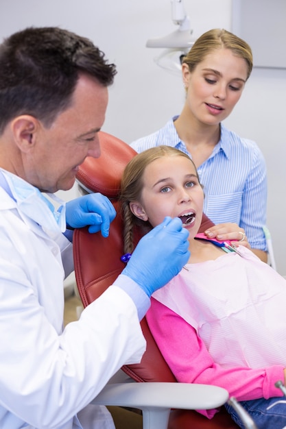 Dentista che esamina con il giovane paziente