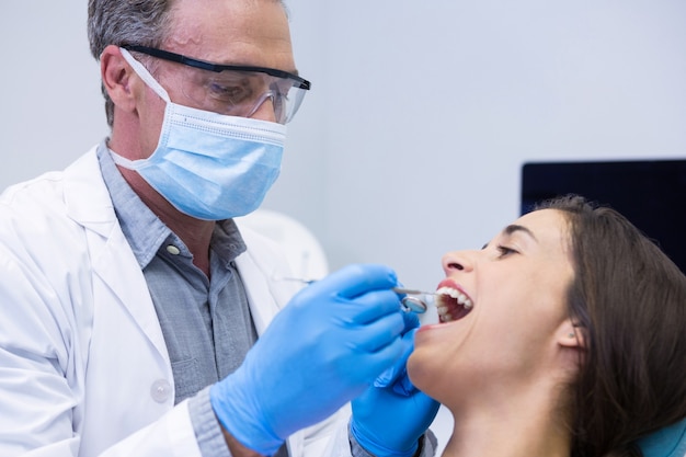 Dentista che esamina donna alla clinica