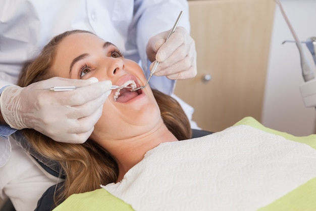 Dentista che esamina i denti dei pazienti nella sedia dei dentisti