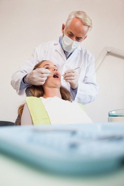 Dentista che esamina i denti dei pazienti nella sedia dei dentisti