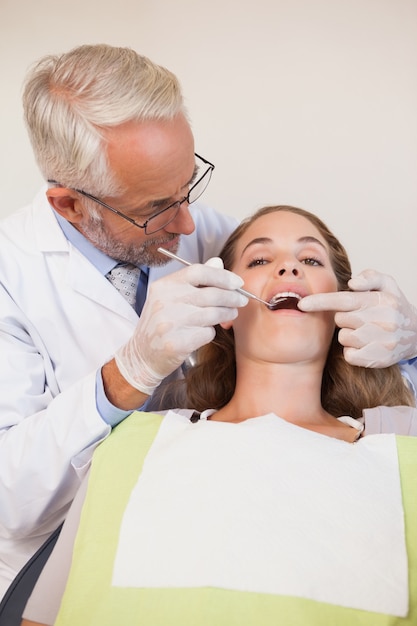 Dentista che esamina i denti dei pazienti nella sedia dei dentisti