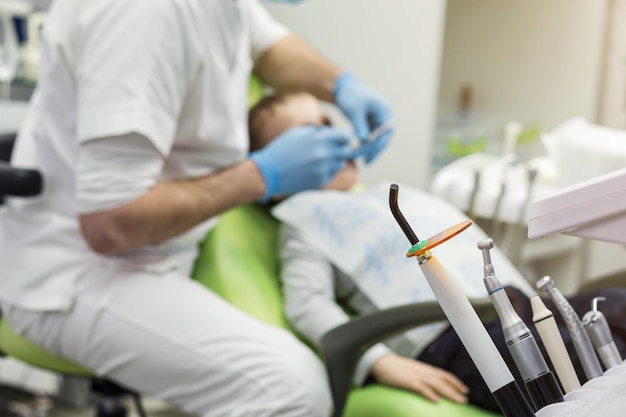 Dentista che esamina i denti del ragazzino in clinica Problema dentale