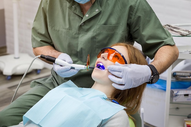 Dentista che esamina i denti della ragazza in clinica Problema dentale Sorriso sano