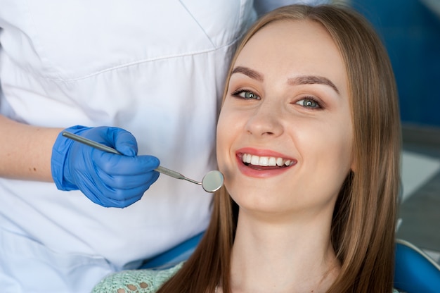 Dentista che esamina i denti di un paziente nella clinica dentale.