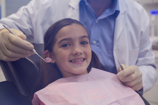 Dentista che esamina un giovane paziente con gli strumenti