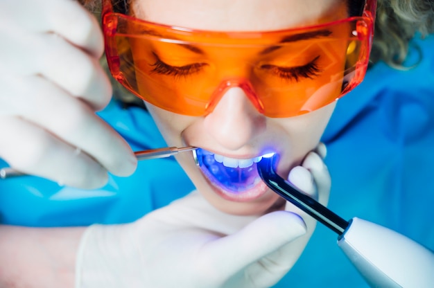 Dentista che esamina un paziente con luce UV