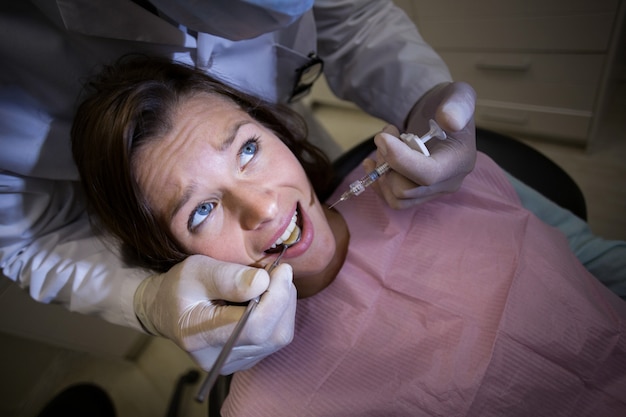 Dentista che inietta paziente femminile