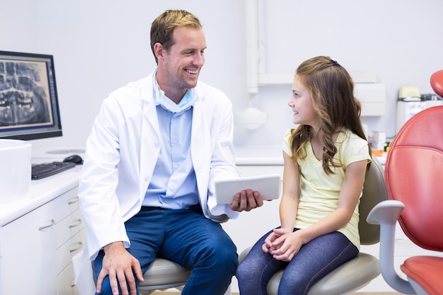 Dentista che interagisce con il giovane paziente in clinica odontoiatrica