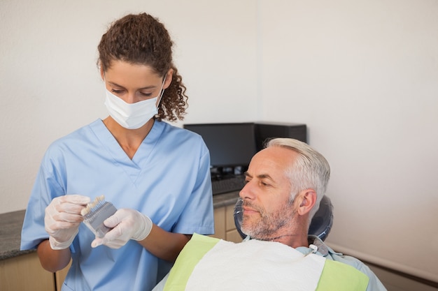 Dentista che mostra il modello paziente dei denti