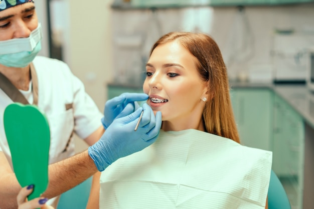 Dentista che mostra il risultato del trattamento per il paziente.